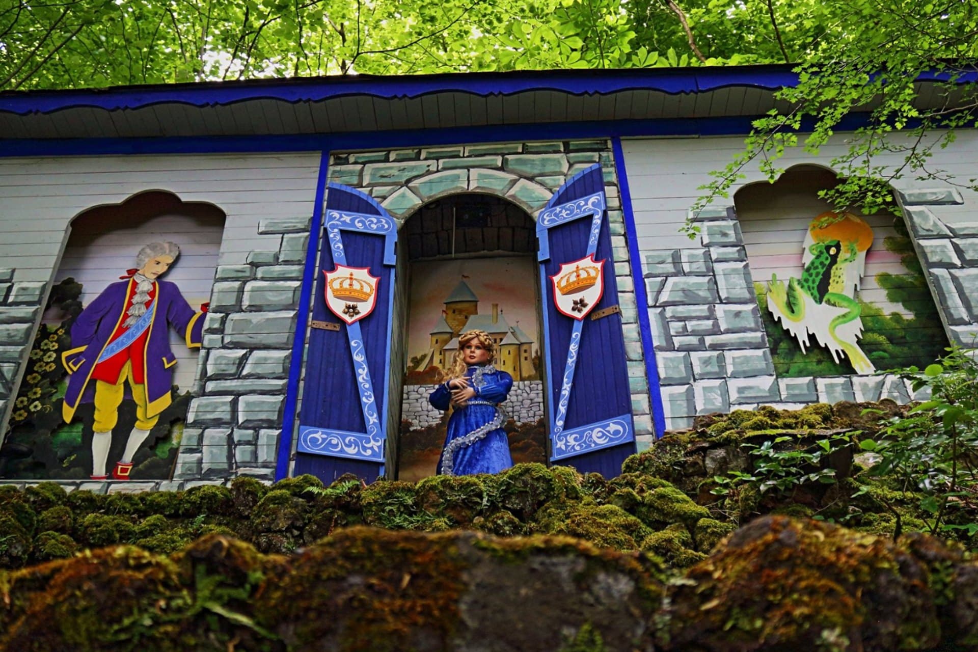 Märchenhaus zum Froschkönig: Prinzessin in der blauen Tür, daneben der gemalte Prinz und der Frosch
